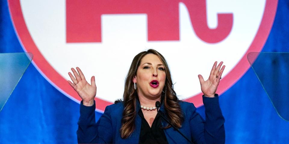 Ronna McDaniel talking with hands raised in front of GOP sign