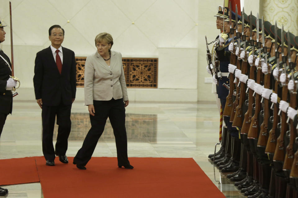 German Chancellor Angela Merkel, center right, and Chinese Premier Wen Jiabao center left, walk together before inspecting a guard of honor during a welcome ceremony at the Great hall of the People in Beijing, Thursday, Aug. 30, 2012. (AP Photo/Ng Han Guan)