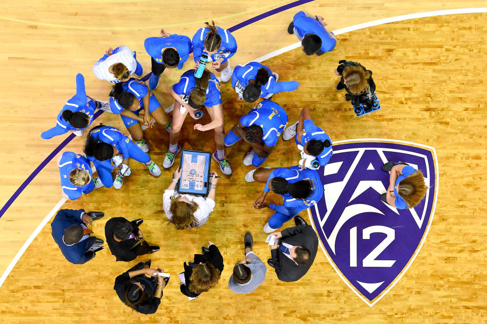 UCLA women's basketball team huddles from above.