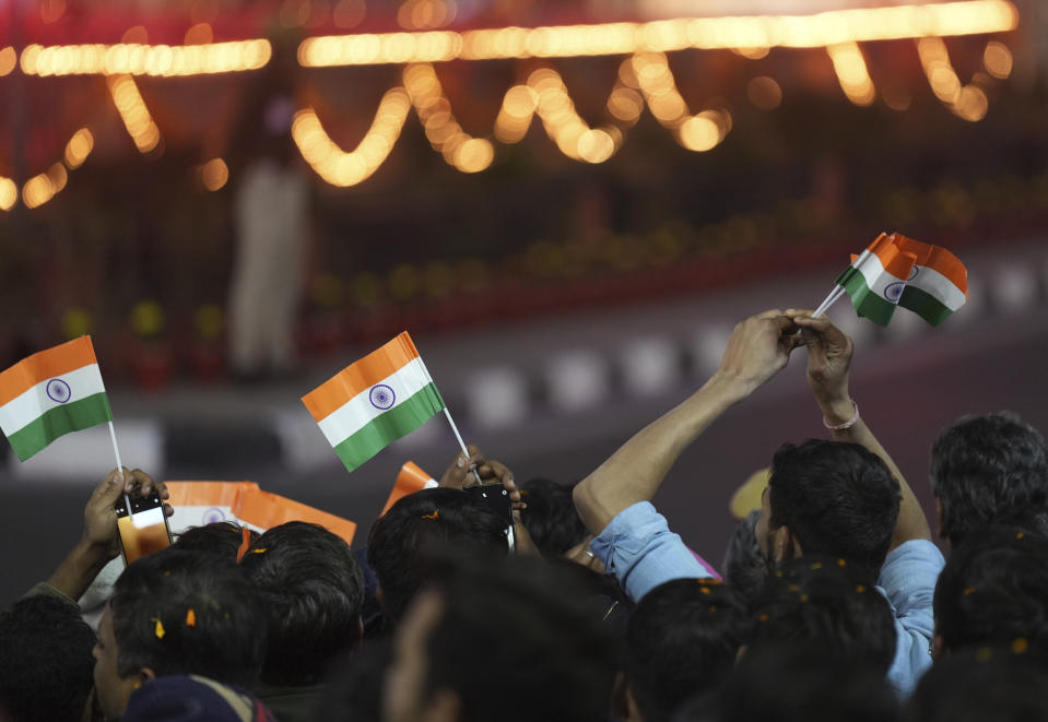 People wave the Indian national flags as they watch French President Emmanuel Macron and Indian Prime Minister Narendra Modi, unseen, during a road show in Jaipur, Rajasthan, India, Thursday, Jan. 25, 2024. Macron will be the chief guest at India's annual republic day parade in New Delhi on Friday. (AP Photo/ Deepak Sharma)