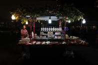 In this Feb. 12, 2020 photo, a young man works at a stand selling cakes and other deserts, after nightfall on a central plaza in Irapuato, Guanajuato state, Mexico. Most investors - and even local officials - seem prepared to ignore the murder wave as gang members kill gang members. “There are victims who are caught in the crossfire, and they are the ones I really feel sorry for," said Mayor Ricardo Ortiz. "But we can’t be expected to protect people who are doing bad things.” (AP Photo/Rebecca Blackwell)