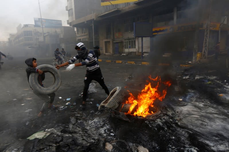 Manifestantes iraquíes queman neumáticos para bloquear una calle durante las protestas antigubernamentales en Najaf, Irak, el 28 de noviembre de 2019