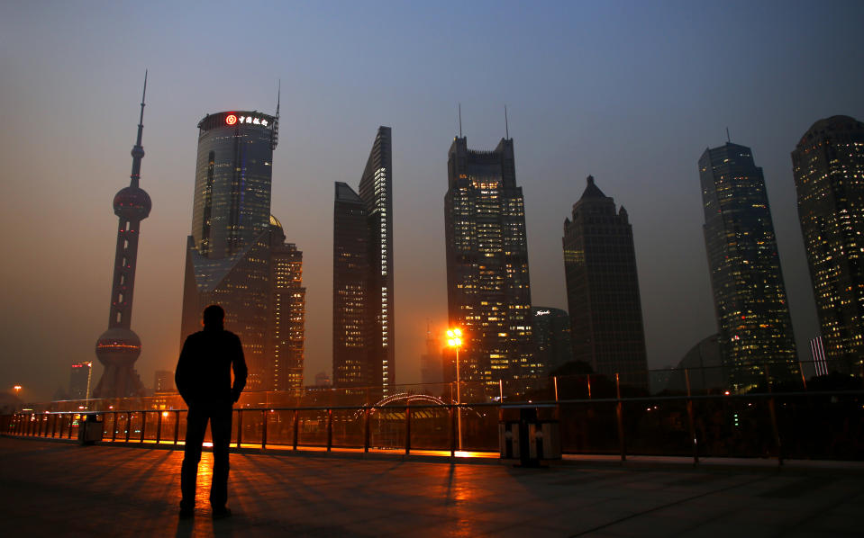 A man looks at the Pudong financial district of Shanghai November 20, 2013. With a shift in tone and language, China's central bank governor has dangled the prospect of speeding up currency reform and giving markets more room to set the yuan's exchange rate as he underlines broader plans for sweeping economic change. The central bank under Zhou Xiaochuan has consistently flagged its intention to liberalise financial markets and allow the yuan to trade more freely, even before the Communist Party's top brass unveiled late last week the boldest set of economic and social reforms in nearly three decades.   REUTERS/Carlos Barria (CHINA - Tags: BUSINESS CITYSCAPE TPX IMAGES OF THE DAY)