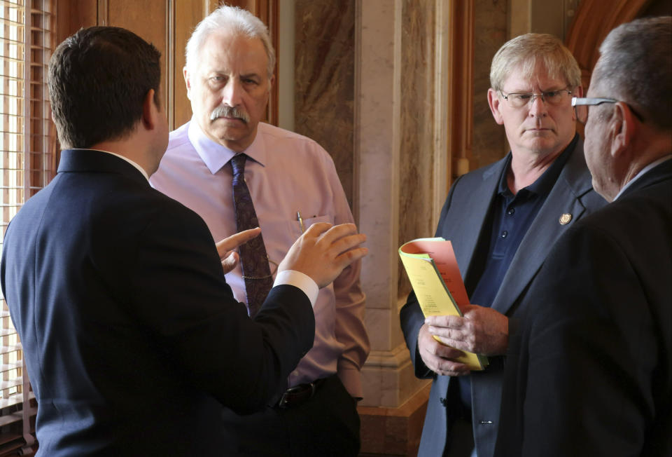 Republican members of the Kansas House confer as they wait for a vote on a proposed state budget, Saturday, May 4, 2019, at the Statehouse in Topeka, Kan. They are, from left to right, Reps. J.R. Claeys, R-Salina; John Resman, R-Olathe; Leo Delperdang, R-Wichita, and Emil Bergquist, R-Wichita. (AP Photo/John Hanna)