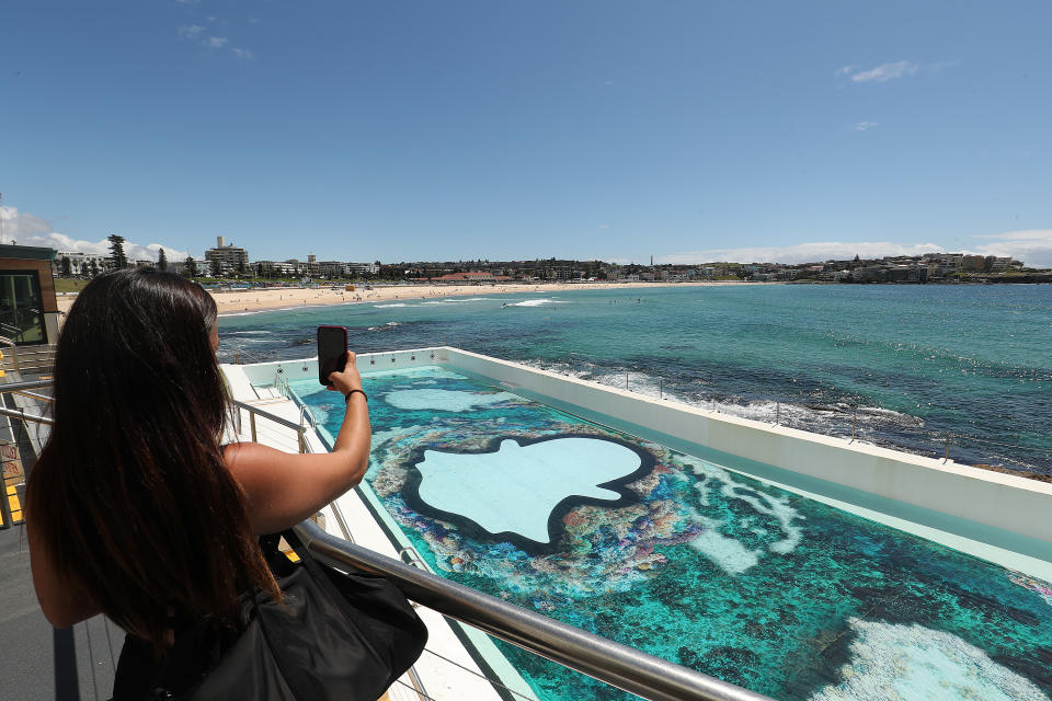 SYDNEY, AUSTRALIA - DECEMBER 02: A women takes a photo of the Icebergs pool during the Snapchat x Great Barrier Reef Foundation announcement at Bondi Icebergs on December 02, 2021 in Sydney, Australia. (Photo by Mark Metcalfe/Getty Images)