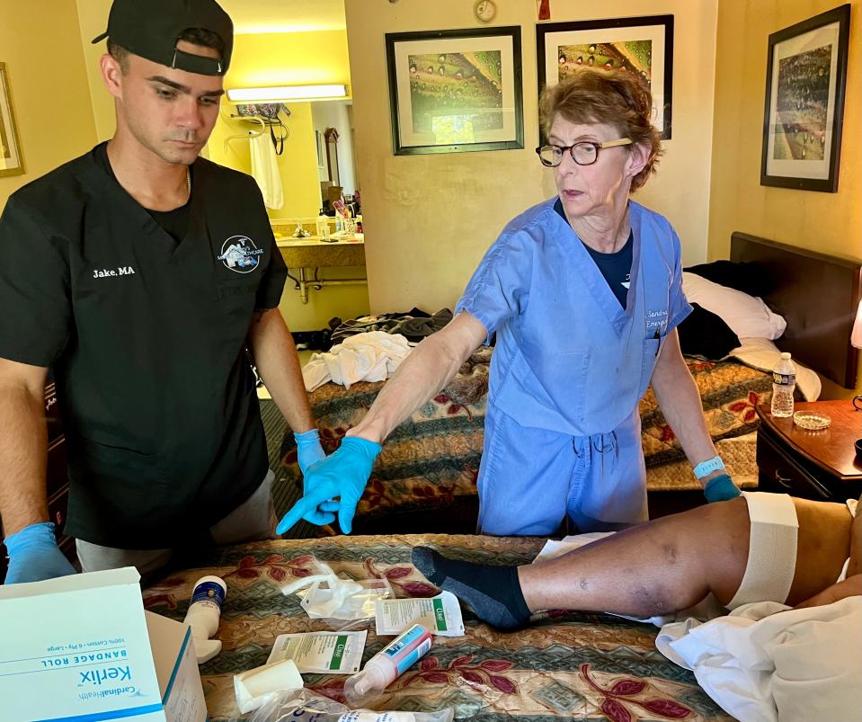 Dr. Sandra Gibney, right, treats a xylazine wound on a woman's leg at a local motel on Thursday, April 20, 2023. Xylazine, an animal tranquilizer, is being mixed with fentanyl. It causes horrific wounds on users' bodies.