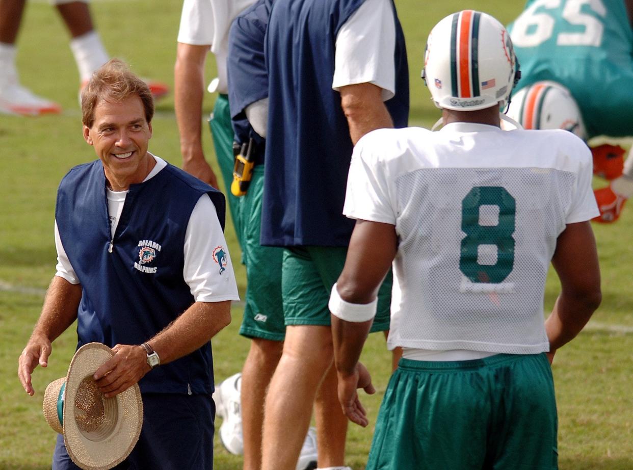 Miami Dolphins head coach Nick Saban, left, smiles at quarterback Daunte Culpepper (8) during summer football camp on July 31, 2006