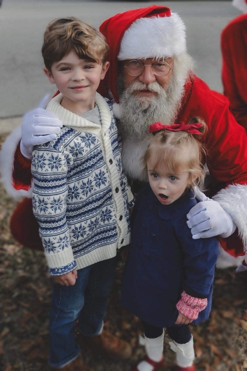 Ranlo siblings Max and Isla stand with Santa at an event Dec. 16, 2023.
