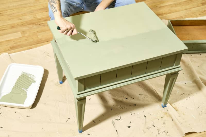 overhead shot of the second coat of paint being applied to the top of the table