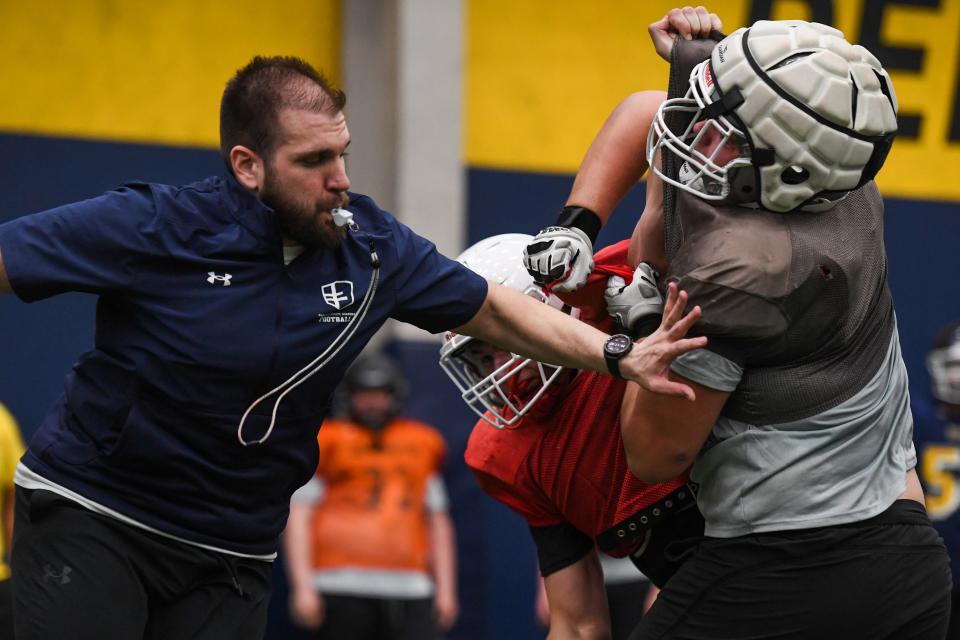 A coach breaks up a tackle between two athletes for a drill during the 2024 Sanford Sports Football Academy Combine on Friday, April 26, 2024, at Sanford Fieldhouse in Sioux Falls.