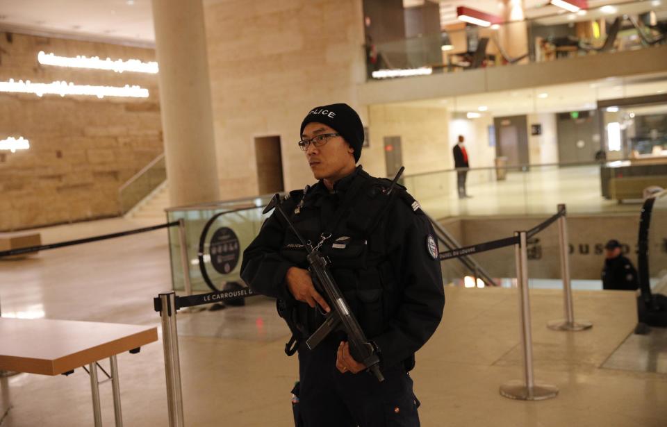 A police officer patrols inside the Louvre Museum after a shooting outside at the museum in Paris, Friday Feb. 3, 2017. A knife-wielding man shouting "Allahu akbar" attacked French soldiers on patrol near the Louvre Museum Friday in what the president called a terrorist attack. (AP Photo/Christophe Ena)