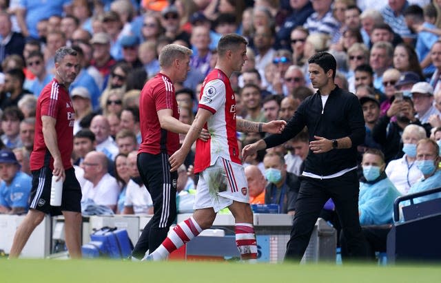 Arsenal's Granit Xhaka walks past beleaguered manager Mikel Arteta after being sent off at Manchester City