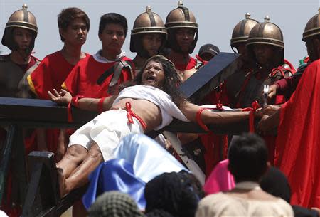 Penitent Ruben Enaje, in his 28th year of crucifixion, grimaces as he is nailed to the cross, in a re-enactment of the death of Jesus Christ on Good Friday in San Fernando, Pampanga in northern Philippines April 18, 2014. REUTERS/Erik De Castro