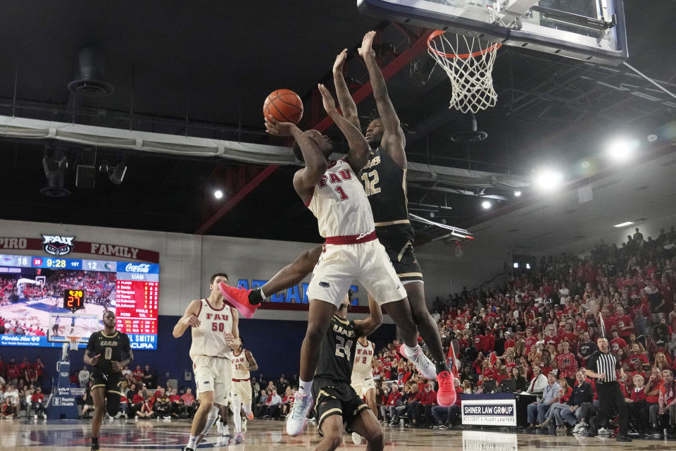 Florida Atlantic guard Johnell Davis (1) drives to the basket as UAB guard Tony Toney (12) defends during the first half of an NCAA college basketball game, Sunday, Jan. 14, 2024, in Boca Raton, Fla. (AP Photo/Marta Lavandier)