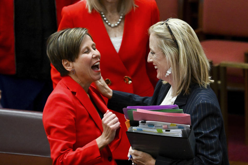 Australian Finance Minister Katy Gallagher, right, and Assistant Minister for Climate Change Jenny MacAllister react after the passing of the Safeguard Mechanism bill in the Senate chamber at Parliament House in Canberra, Thursday, March 30, 2023. The Australian Parliament created landmark new laws Thursday that will make the nation’s biggest greenhouse gas polluters reduce their emissions or pay for carbon credits. (Lukas Coch/AAP Image via AP)