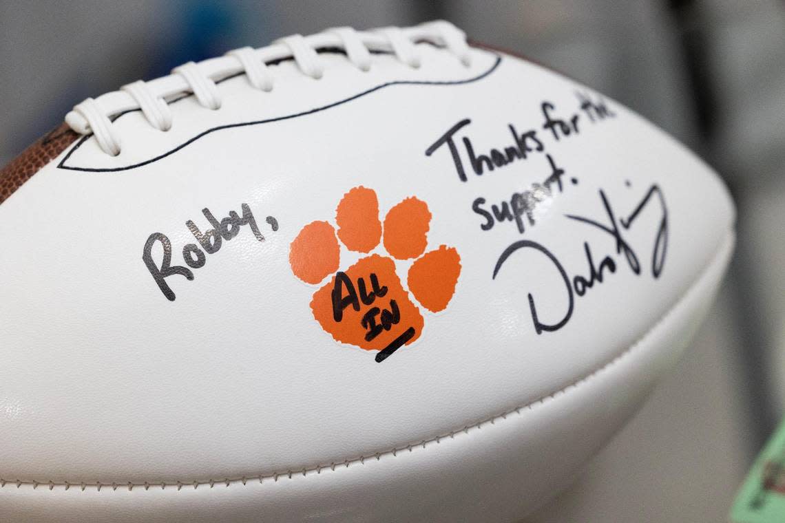 Robby Shealy shows a football signed by Clemson head football coach Dabo Swinney at his home on Thursday, December 15, 2022. Shealy has attended home and away games consistently for decades.