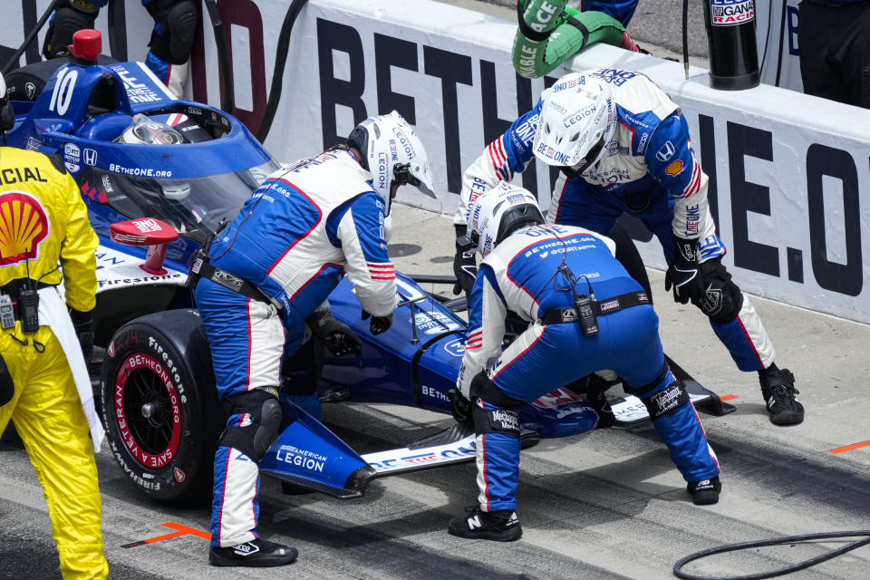 The crew of Alex Palou, of Spain, changes the front wing on the car after he was hit in the pit area during the Indianapolis 500 auto race at Indianapolis Motor Speedway in Indianapolis, Sunday, May 28, 2023. (AP Photo/AJ Mast)