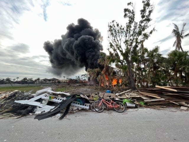 Debris from Hurricane Ian in the foreground as a fire rages at the golf course at Sanibel's The Dunes Golf and Tennis Club on Friday, Nov. 18, 2002. Golf carts at the club caught on fire.