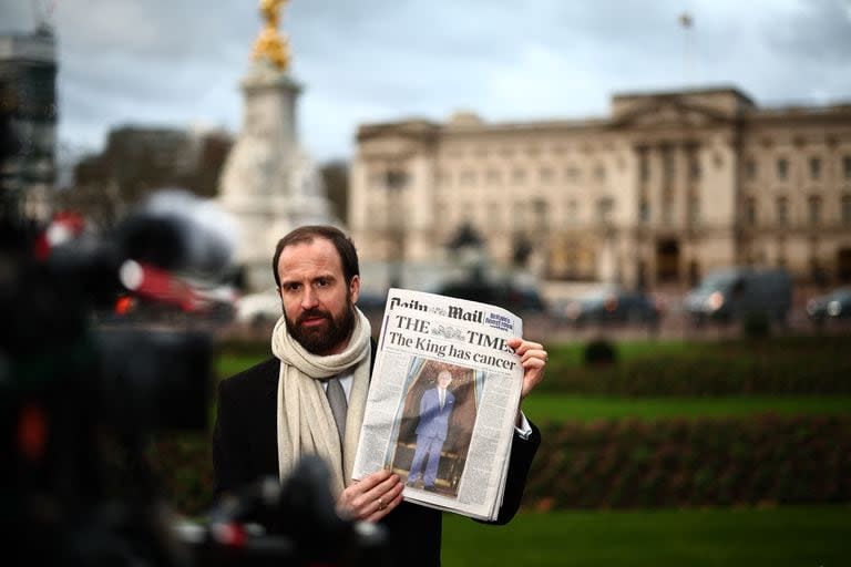 Un periodista muestra la tapa del The Times frente al Palacio de Buckingham, en Londres. (HENRY NICHOLLS / AFP)