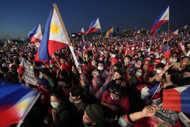 A supporter dressed in a spiderman costume hold a Philippine flag as they wait for Presidential candidate, Ferdinand Marcos Jr., the son of the late dictator, during their last campaign rally known as "Miting De Avance" on Saturday, May 7, 2022 in Paranaque city, Philippines. Marcos Jr. and the current Vice-President Leni Robredo continue to lead against other presidential candidates as the country prepares to vote for it's new leader next week. (AP Photo/Aaron Favila)