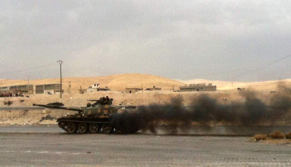 A picture taken on December 3, 2013 shows a tank of pro regime forces smoking as it drives near al-Nabak, in the Qalamoun region on the outskirts of the capital Damascus, where they battle with rebel fighters. (SAM SKAINE/AFP/Getty Images)