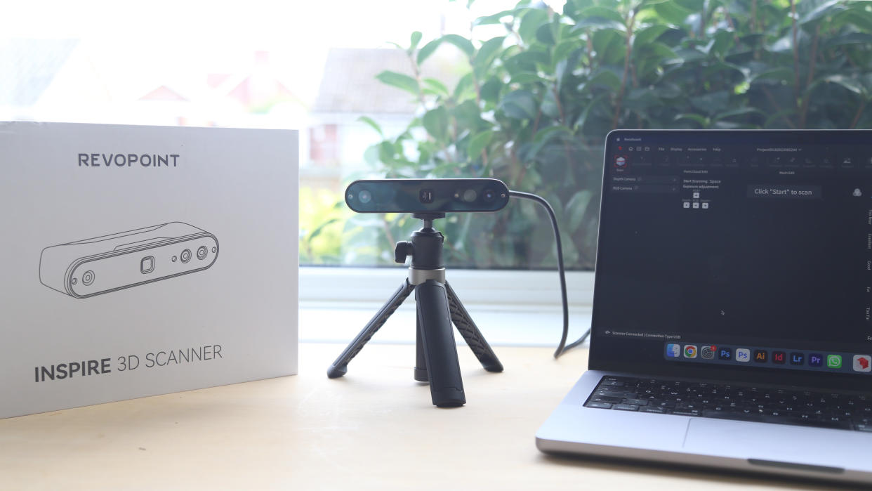  A Revopoint INSPIRE 3D Scanner on a desk, along with an object to scan and a laptop. 