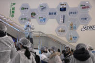 In this Thursday, Feb. 27, 2020, photo, journalists dressed in protective overalls visit the Mengniu dairy factory in Beijing. Reporters were invited to China Mengniu Dairy Co. Ltd. this week to be shown how companies are reviving after anti-virus measures shut down most of the world's second-biggest economy. (AP Photo/Ng Han Guan)