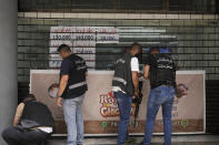 Lebanese General Security officers close a shop employing Syrians, as part of a crackdown on businesses employing unregistered Syrian workers in Beirut, Lebanon, Saturday, May 11, 2024. Hundreds of Syrians refugees left a remote northeastern Lebanese town back to Syria in a convoy Tuesday, amid a surge in anti-refugee sentiment in the small, crisis-hit country. The new push for repatriation comes as Lebanon's quarrelling ruling political parties have reached a rare consensus in recent years, all agreeing that Syrian refugees should be returned. (AP Photo/Hassan Ammar)