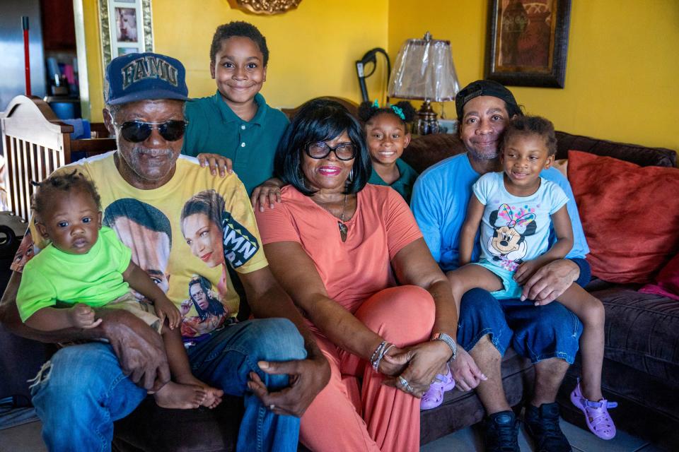 Left to right, Otis Hall holds his grandaughter Hor’Hyrum McCain, with Jimmon Sharpe, 9, Catherine Hall, Joneyah Sharpe, 7, Jimmy Sharpe, and Jontja Sharpe, 3, at the Hall home in Boynton Beach, Florida on November 1, 2022.