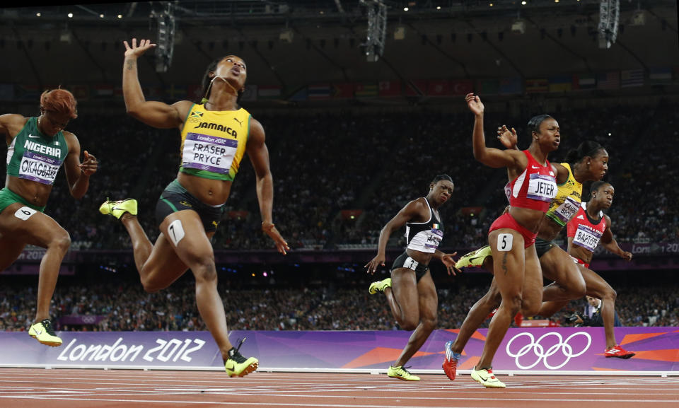 FILE - Jamaica's Shelly-Ann Fraser-Pryce, second from left, crosses the finish line to win gold ahead of United States' Carmelita Jeter, third from right, Jamaica's Veronica Campbell-Brown, second from right, Trinidad's Kelly-Ann Baptiste, right, Ivory Coast's Murielle Ahoure, third from left, and Nigeria's Blessing Okagbare, left, in the women's 100-meter final during the athletics in the Olympic Stadium at the 2012 Summer Olympics, London, Saturday, Aug. 4, 2012. Fraser-Pryce said the Paris Games will be her fifth and final Olympics.(AP Photo/Matt Dunham, File)