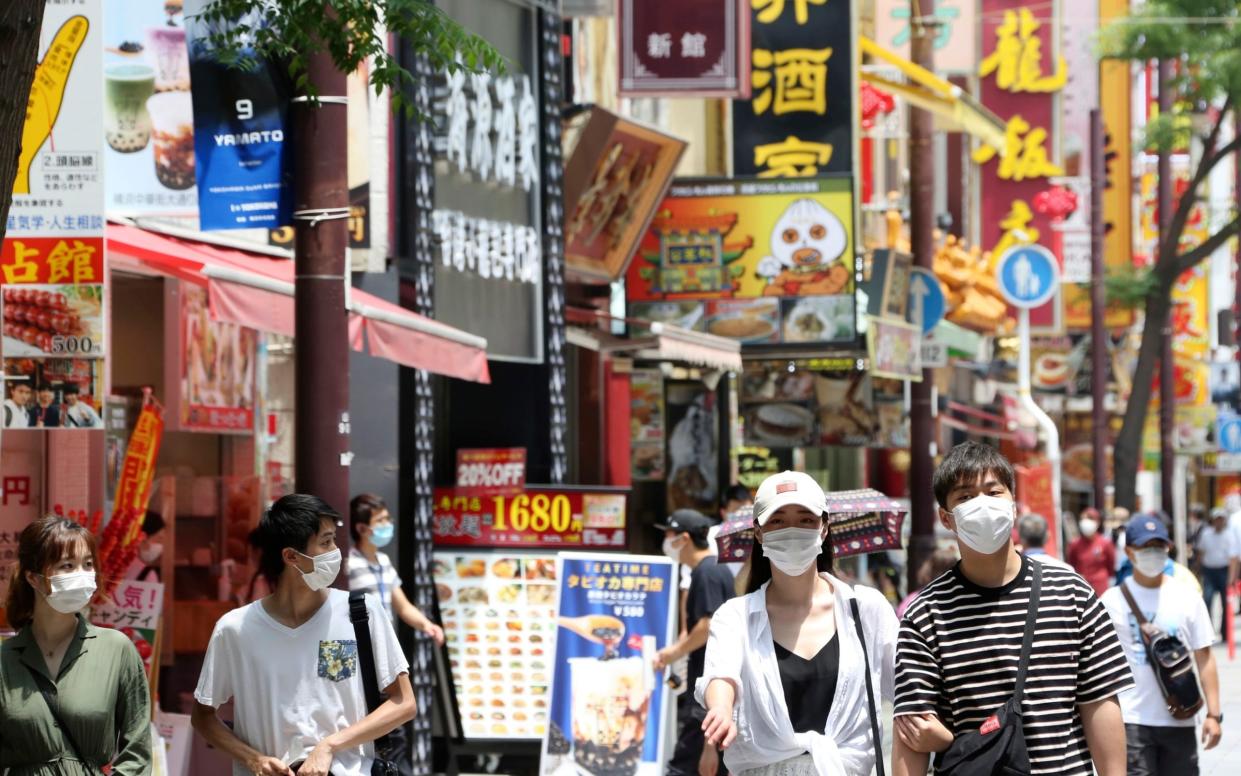 People wear face masks to protect against the spread of coronavirus in Chinatown in Yokohama, near Tokyo - AP Photo/Koji Sasahara