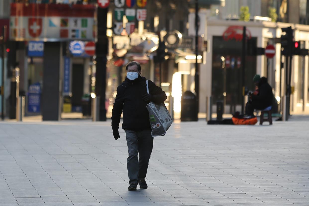 LONDON, UNITED KINGDOM - MARCH 23: A man wears a medical mask as a precaution against coronavirus (Covid-19) at deserted Leicester Square in London, United Kingdom on March 23, 2020. Total number of deaths due to coronavirus reached 335 today in UK. (Photo by Ilyas Tayfun Salci/Anadolu Agency via Getty Images)