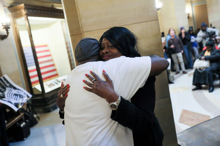 Christina Wilson, holder of the endangered Deferred Enforced Departure (DED) immigration status, hugs another participant after her remarks at the DED rally at the Minnesota State Capitol in St. Paul, Minnesota, U.S. February 22, 2019. Picture taken February 22, 2019. REUTERS/Jonathan Ernst