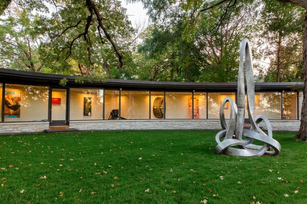 The unusual floor plan includes a long gallery that wraps a grassy courtyard. The family commissioned an aluminum sculpture by Los Angeles–based artist Evan Holloway for the space.