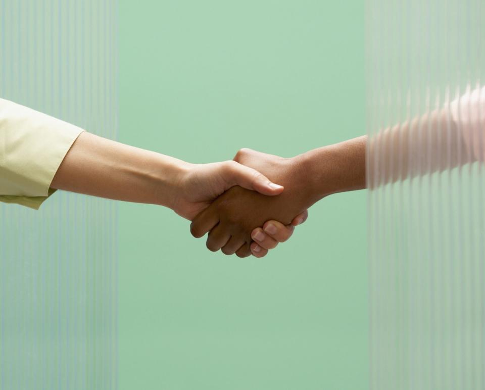How to Follow Up After a Job Interview: two people shaking hands on a green background