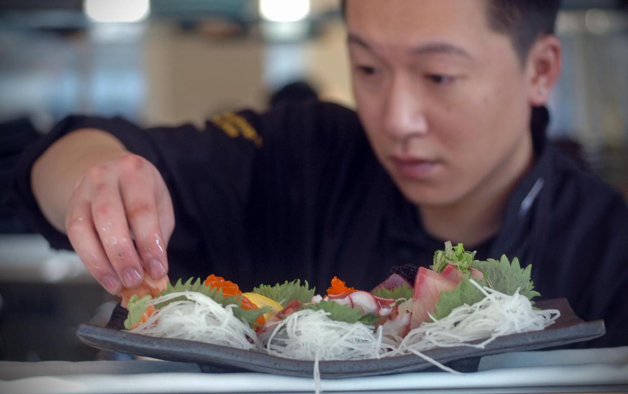 Sushi chef Ming Cao prepares a sashimi dish at Fuji at Kendall.