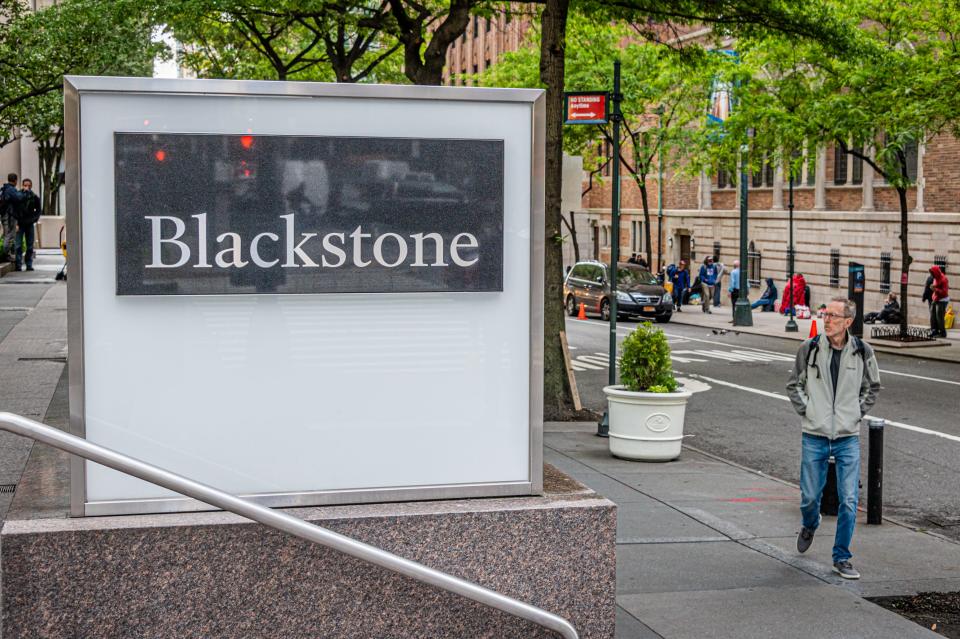 A large stone Blackstone sign on a city street.