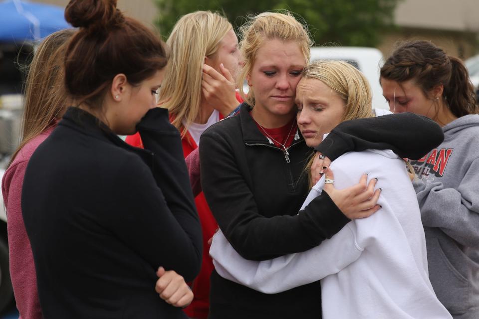 West High School senior students Kelsey Hoelscher, center, and Heather Perry, right, embrace the day after the explosion in West, Texas. Hoelscher's uncles, Bob Snokhous and Doug Snokhous, were volunteer firefighters who were later confirmed killed in the blast.