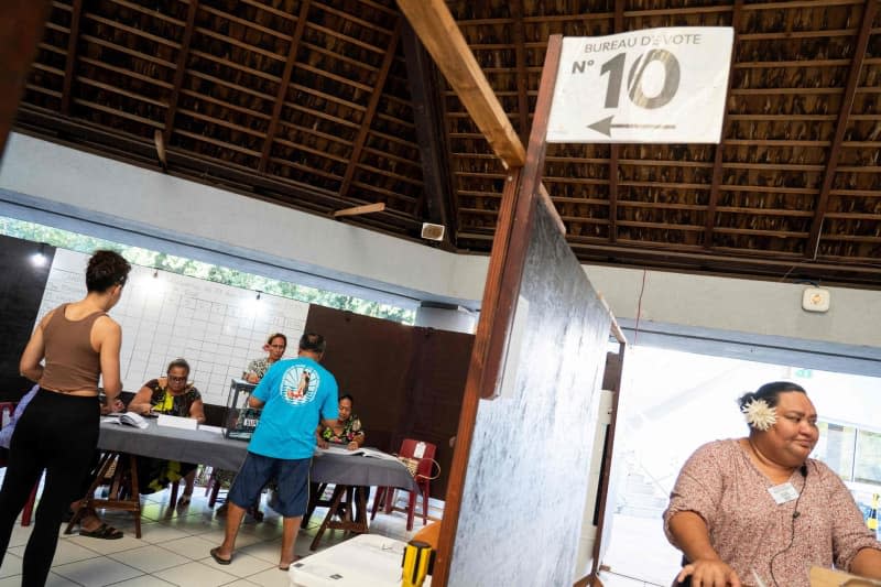 People cast their votes at a polling station during the first round of the French parliamentary elections on the island of Tahiti in the third constituency of the French overseas territory of French Polynesia. Suliane Favennec/AFP/dpa