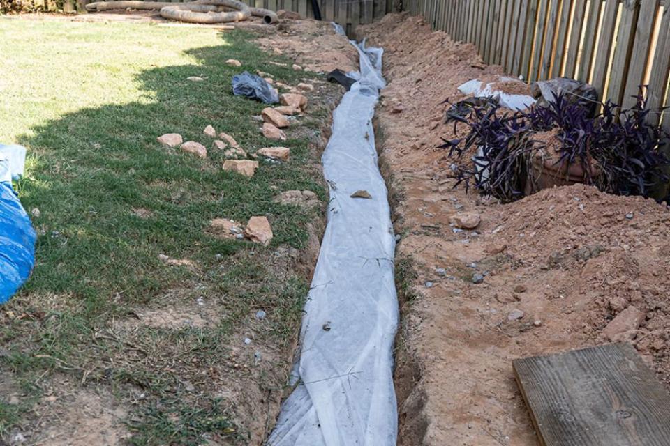 A close up of a french drain during its construction.