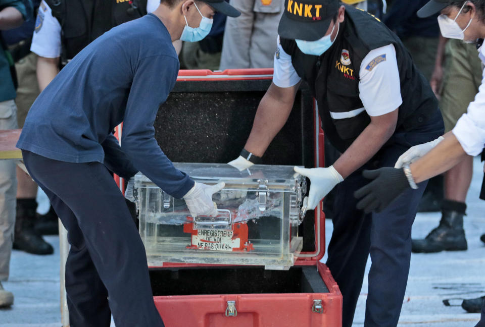 Members of National Transportation Safety Committee place a box containing the flight data recorder of Sriwijaya Air flight SJ-182 retrieved from the Java Sea where the passenger jet crashed into a container after a press conference at Tanjung Priok Port, Tuesday, Jan. 12, 2021. Indonesian navy divers searching the ocean floor on Tuesday recovered the flight data recorder from a Sriwijaya Air jet that crashed into the Java Sea with 62 people on board. (AP Photo/Dita Alangkara)