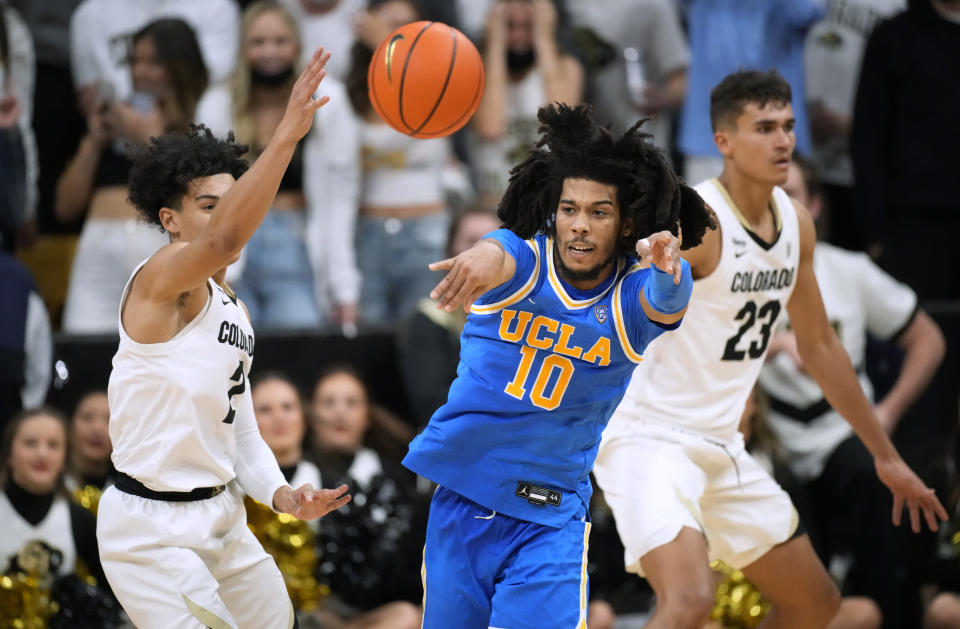 UCLA guard Tyger Campbell (10) passes the ball as Colorado guard KJ Simpson defends during the second half of an NCAA college basketball game Saturday, Jan. 22, 2022, in Boulder, Colo. UCLA won 71-65. (AP Photo/David Zalubowski)