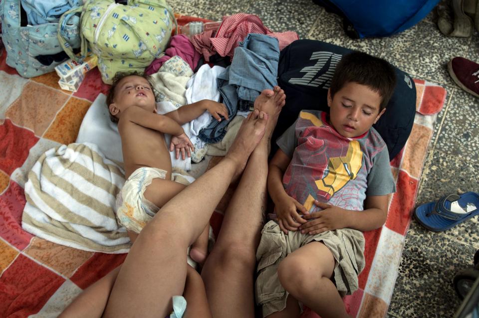 A group of migrants rests at the central park in Ciudad Hidalgo, Mexico, Saturday, Oct. 20, 2018. About 2,000 Central American migrants who circumvented Mexican police at a border bridge and swam, forded and floated across the river from Guatemala decided on Saturday to re-form their mass caravan and continue their trek northward toward the United States. (AP Photo/Oliver de Ros)