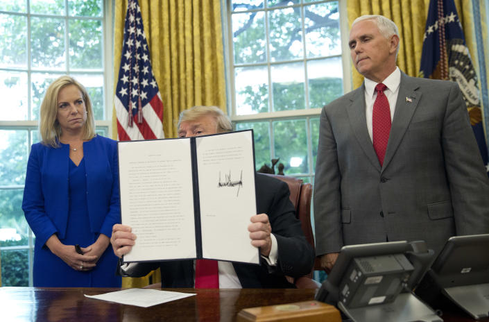 President Trump shows the executive order he signed to end family separations at the border during an event in the Oval Office of the White House on Wednesday in Washington, D.C. Homeland Security Secretary Kirstjen Nielsen and Vice President Mike Pence look on. (Photo: Pablo Martinez Monsivais/AP)