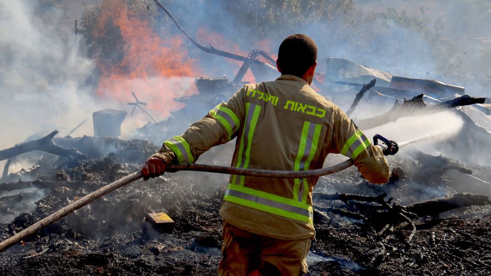 An Israeli firefighter puts out flames in a field after rockets launched from southern Lebanon landed on the outskirts of Kiryat Shmona on June 4. - Jack Guez/AFP/Getty Images
