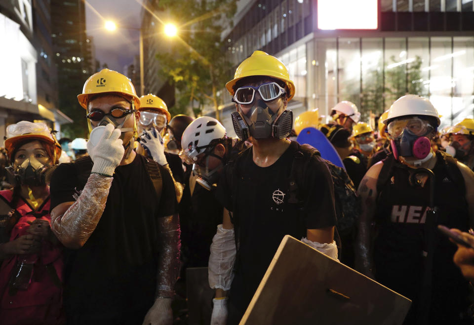 Protestors wear respirators as they gather in Hong Kong, Friday, June 21, 2019. Several hundred protesters, mainly students, gathered Friday outside Hong Kong government offices, with some blocking traffic on a major thoroughfare and others occupying the lobby of a government tax office. (AP Photo/Vincent Yu)