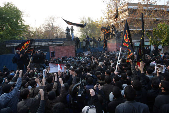 Protesters storm the security gates to the British Embassy during an anti-British demonstration on November 29, in Tehran, Iran. More than 20 Iranian protesters stormed the embassy, removing the mission’s flag and ransacking offices. The British government evacuated its staff and expelled those from the Iranian embassy in London soon after.  (FarsNews/Getty Images)