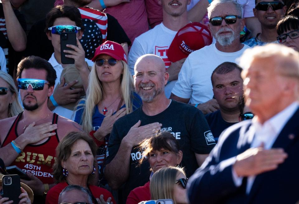 Rally attendees join Former President Donald Trump in placing their hands on their hearts during "Justice for All," moment before the beginning of Trump's speech at his Make America Great Again Rally in Waco, Texas, March 25, 2023. The song by the J6 Prison Choir, made up of people incarcerated for their role in the January 6th attacks of the U.S. Capitol, features Trump.