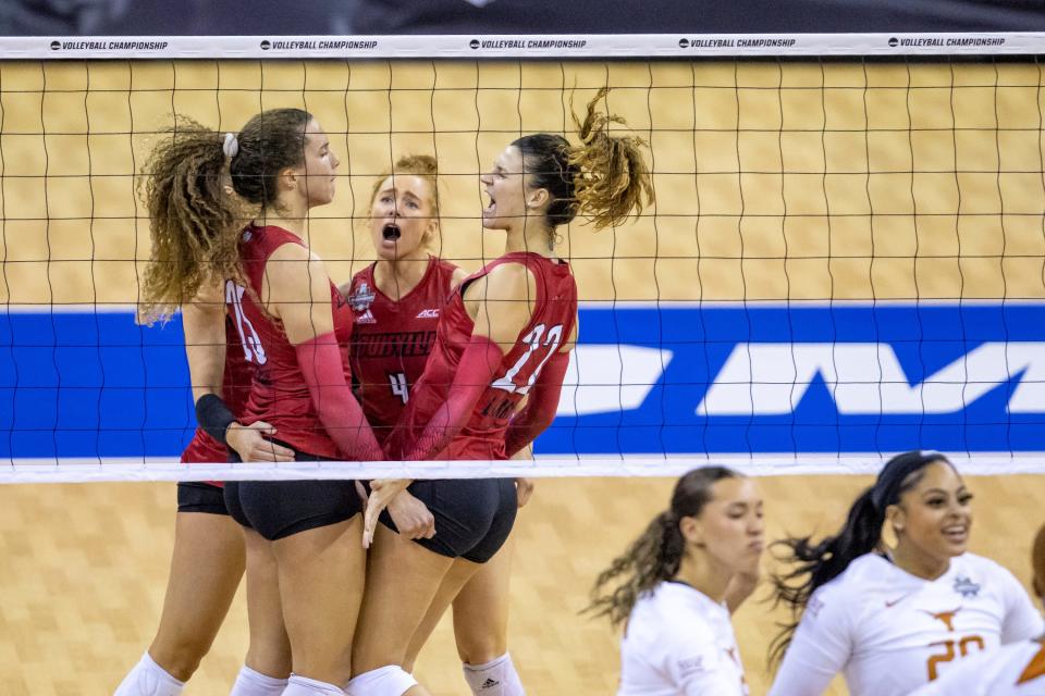 Louisville players, including Amaya Tillman (25), Alexa Hendricks (4) and Raquel Lazaro (22), celebrate after a point against Texas in the third set during the NCAA college volleyball championship finals, Saturday, Dec. 17, 2022, in Omaha, Neb. (AP Photo/John S. Peterson)