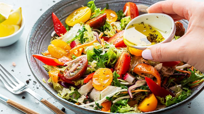 pouring vinaigrette on salad